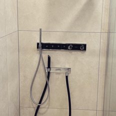 Die Dusche zeigt eine stilvolle Kombination aus Chrom-Armaturen und einem minimalistischen Design in neutralen Farbtönen.