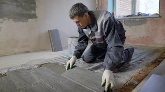 Ein Fliesenleger auf einer Baustelle