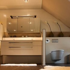 Das Badezimmer zeigt eine schlichte, aber elegante Einrichtung mit einem hellen Holzschrank und einem modernen WC.