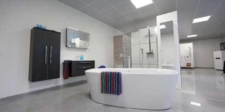 Ein modernes Badezimmer mit einer freistehenden Badewanne, die mit einem bunten Handtuch dekoriert ist.