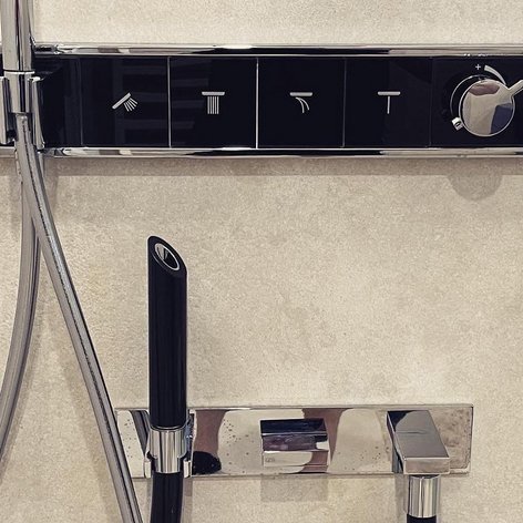 Das Bild zeigt eine stilvolle Duscharmatur mit klaren Symbolen für verschiedene Funktionen und einem Temperaturregler.