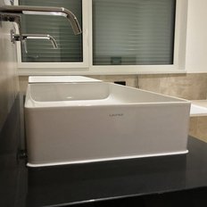 Die stilvollen Waschbecken sind nebeneinander angeordnet, mit glänzenden Wasserhähnen und einem Fenster im Hintergrund.